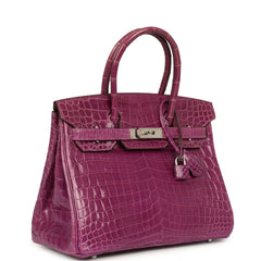 Hermes Birkin 30, a violet shiny Niloticus crocodile bag with palladium hardware and a dangling padlock.