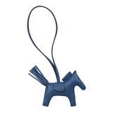 Hermès Rodeo Bag Charm PM Bleu Tie, a horse-shaped Milo lambskin charm with a thin strap and fringed tail.