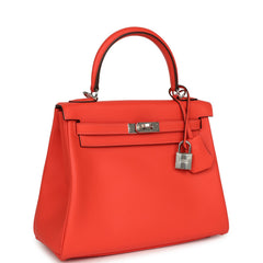 Hermès Kelly Retourne 25 Orange Field Swift bag with palladium hardware, top handle, front flap, and hanging padlock.
